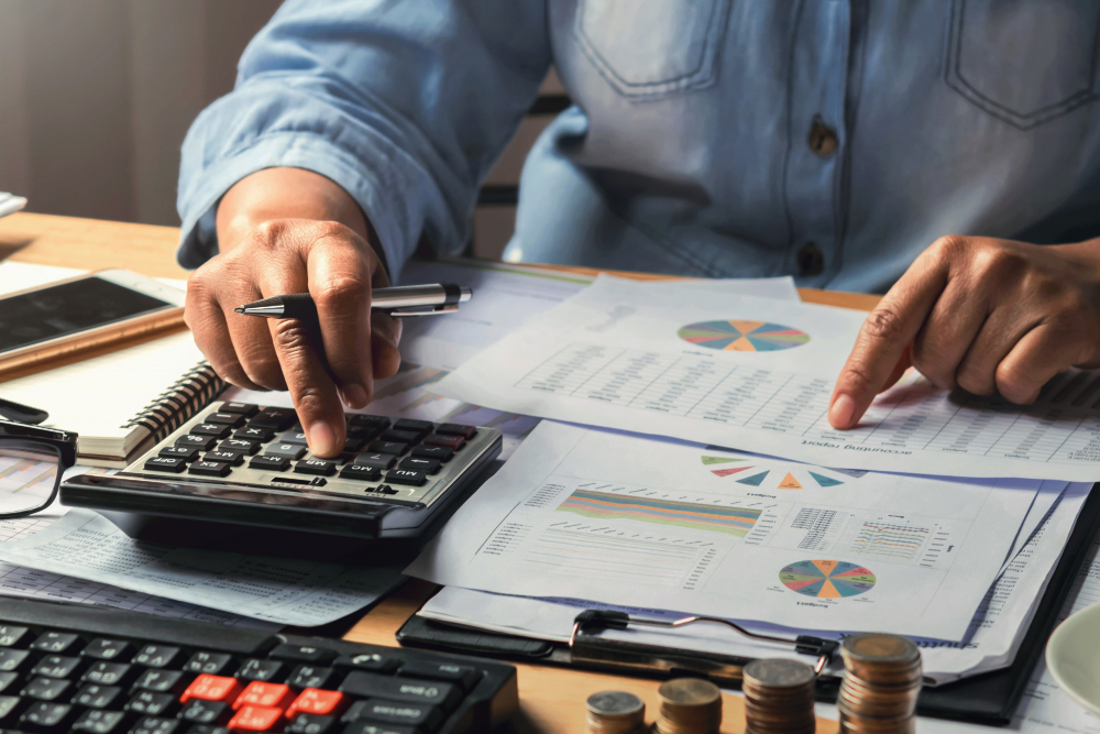 accounting-concept-businesswoman-working-using-calculator-with-money-stack-office